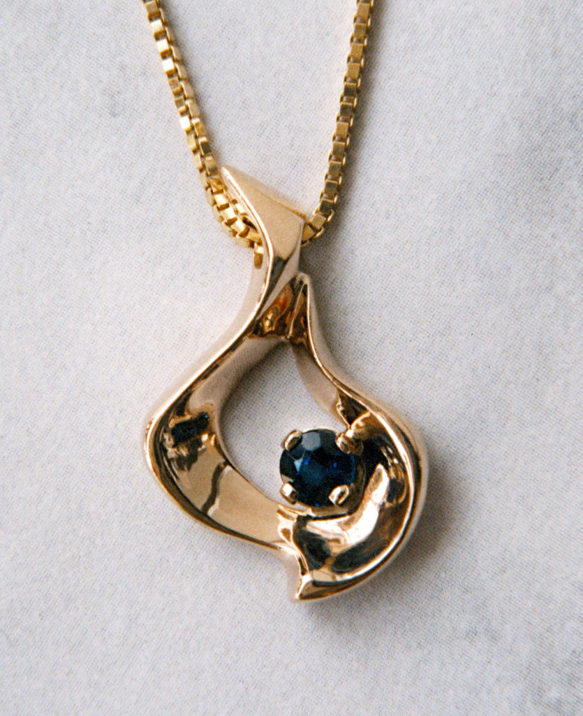 Picture of a 14KY "Squiggly Pendant" with Sapphire. Originally carved in wax and cast.