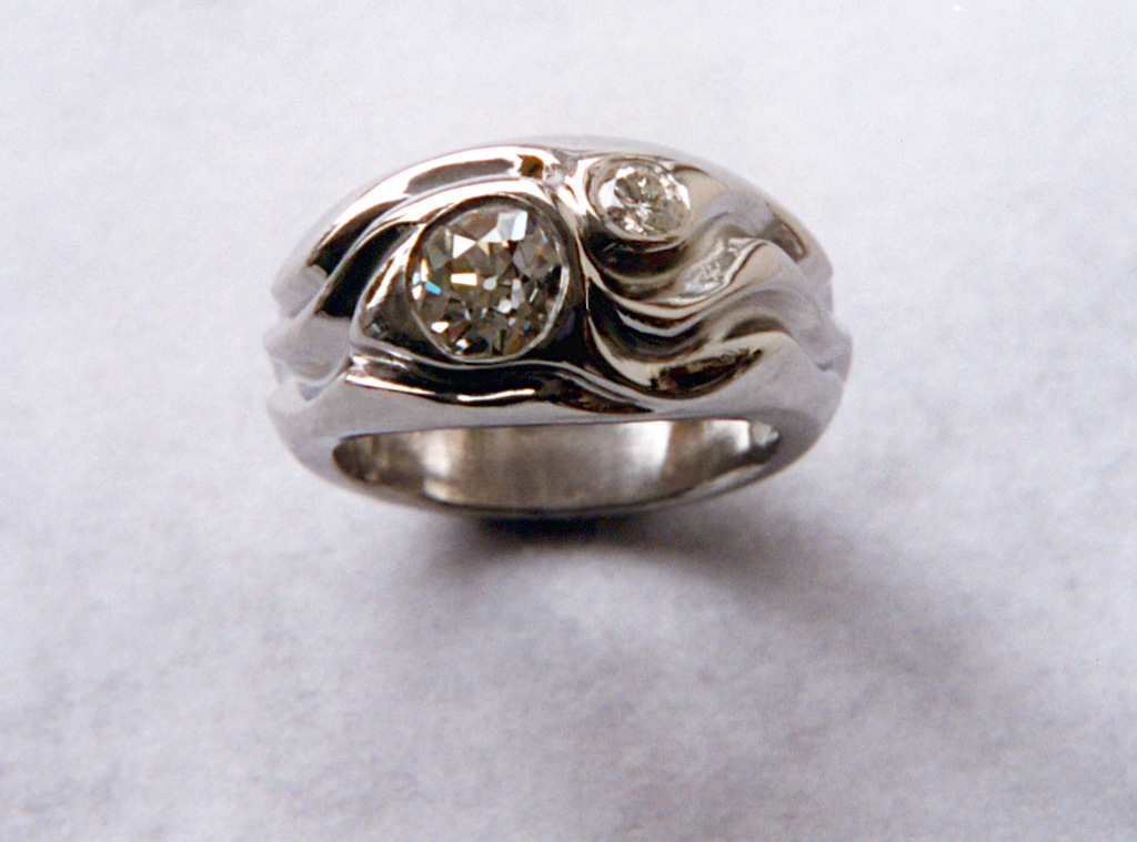 Picture of a carved ring with 2 diamonds. Top view.